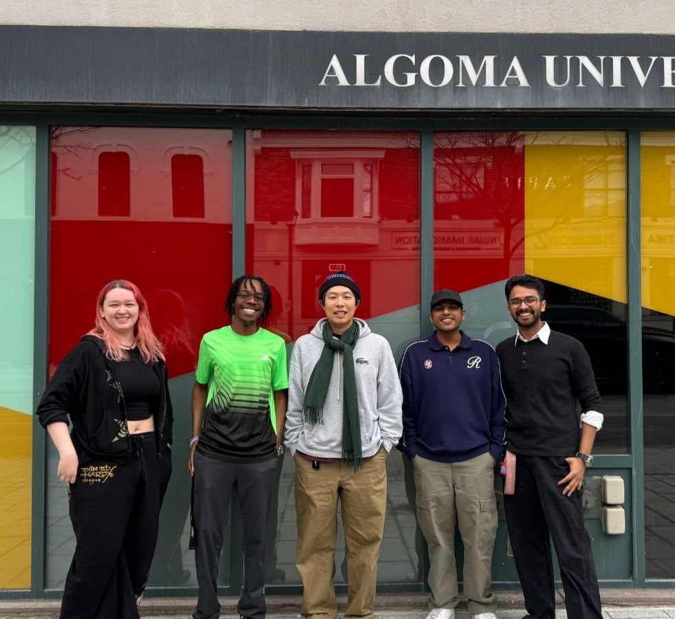 Five SLIDE Studio lab members standing in front of the Algoma University building